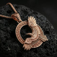 Load image into Gallery viewer, Rose gold plated Celtic raven knotwork pendant necklace on textured volcanic rock, centered studio-style close-up showcasing soft rosy glow and intricate braided Celtic detailing throughout the design.
