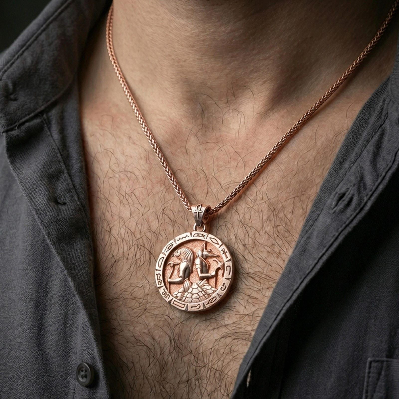 Rose gold plated Horus and Anubis pendant necklace worn on the neck, lifestyle wear shot with elegant rosy shine and crisp deity-and-hieroglyph detailing visible.