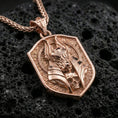 Load image into Gallery viewer, Rose gold plated Anubis pendant necklace on textured volcanic rock, centered studio-style close-up showcasing soft rosy glow and intricate Egyptian-inspired jackal-and-skull detailing.
