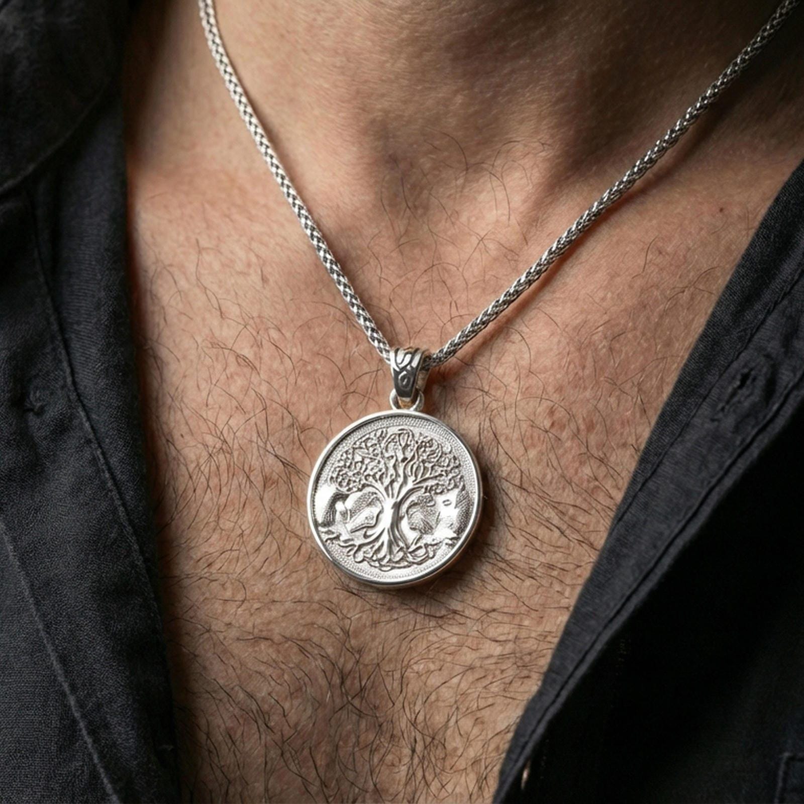 Polished silver Yggdrasil tree of life pendant necklace worn on the neck, clean lifestyle wear shot capturing bright shine and the detailed tree-and-wolves relief in natural light.