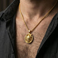 Load image into Gallery viewer, Gold plated demon mask medallion pendant necklace worn on the neck, lifestyle photo featuring warm tone finish and strong statement pendant presence.
