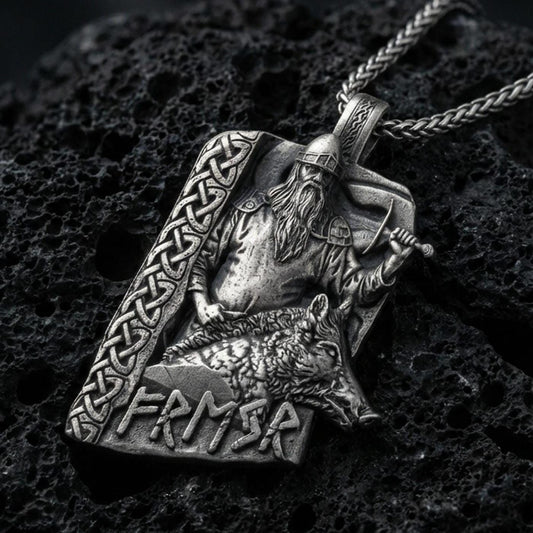 Oxidized Freyr and Gullinbursti pendant necklace on textured volcanic rock, centered close-up highlighting the Viking god relief, boar motif, rune lettering, and deep antique shadowed contrast.