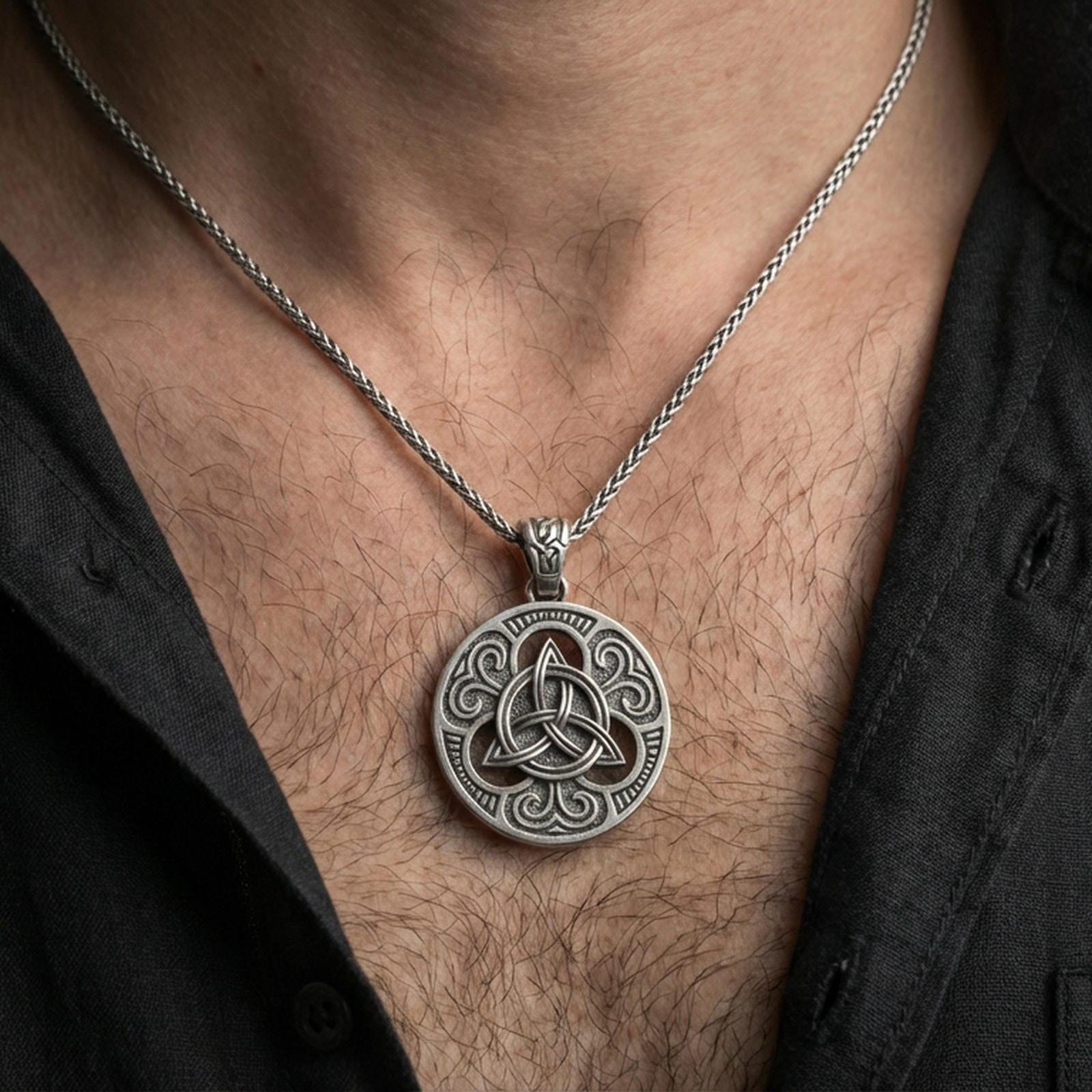 Oxidized Celtic triquetra pendant necklace worn on the neck, lifestyle framing showing realistic scale and bold vintage contrast against the chest.
