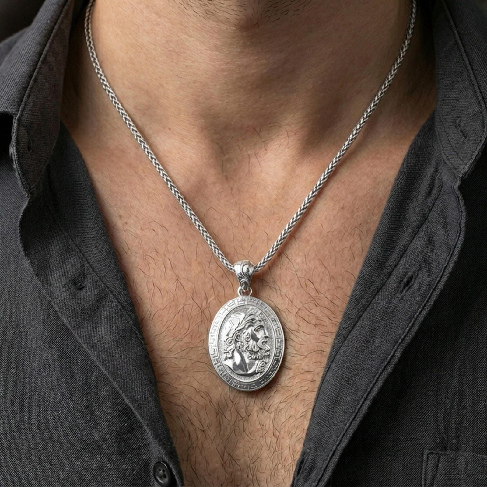 Polished silver Hades coin pendant necklace worn on the neck, clean lifestyle wear shot capturing bright shine and the detailed laurel-crowned profile in natural light.