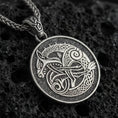 Load image into Gallery viewer, Oxidized Urnes style Viking beast pendant necklace on textured volcanic rock, centered close-up highlighting the interlaced Norse animal motif, braided knotwork, and deep antique shadowed contrast.
