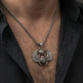 Load image into Gallery viewer, Oxidized winged scarab beetle pendant necklace worn on the neck, lifestyle framing showing realistic scale and bold vintage contrast against the chest.
