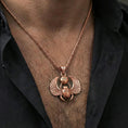 Load image into Gallery viewer, Rose gold plated winged scarab beetle pendant necklace worn on the neck, lifestyle wear shot with elegant rosy shine and crisp scarab-and-wing detailing visible.
