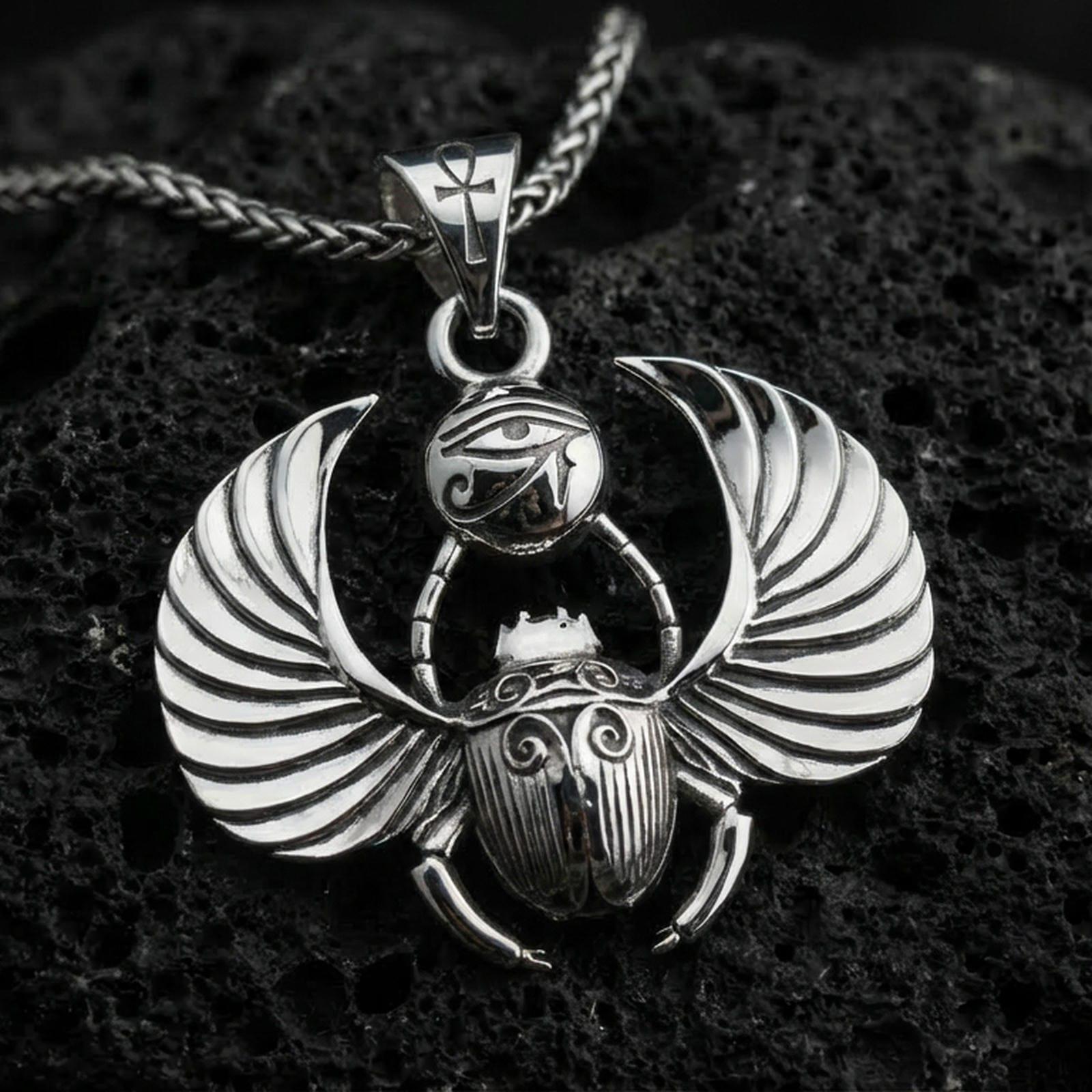 Polished silver winged scarab beetle pendant necklace on textured volcanic rock, crisp macro product photo emphasizing clean edges, sharp feathered wing lines, and bright reflective highlights on the Eye of Ra emblem.