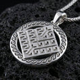 Load image into Gallery viewer, Polished silver geometric rune-style medallion pendant necklace on textured volcanic rock, crisp macro product photo emphasizing clean edges, sharp angular relief, and bright reflective highlights across the round frame.
