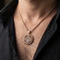 Load image into Gallery viewer, Rose gold plated geometric rune-style medallion pendant necklace worn on the neck, lifestyle wear shot with elegant rosy shine and crisp geometric detailing visible.

