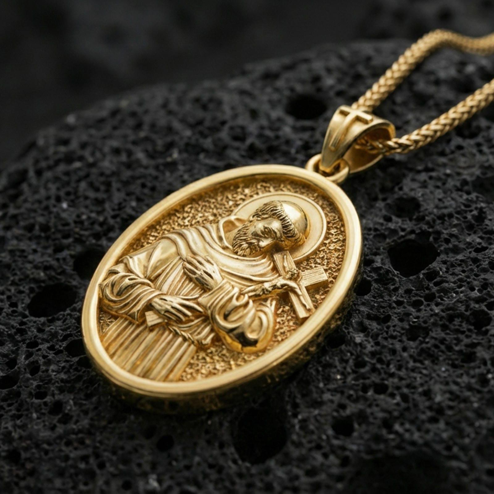Gold plated Saint Francis pendant with sculpted religious figure, haloed portrait, and cross detail showcased on black volcanic rock in a refined macro jewelry image