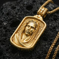 Load image into Gallery viewer, Gold plated Virgin Mary necklace with sculpted sacred portrait, geometric engraved background, and rounded rectangular silhouette showcased on black volcanic rock in a refined macro jewelry image
