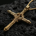 Load image into Gallery viewer, Gold plated biomechanical cross pendant with futuristic gothic styling, raised organic-metal textures, and detailed mechanical patterning showcased on black volcanic rock in a refined macro jewelry image
