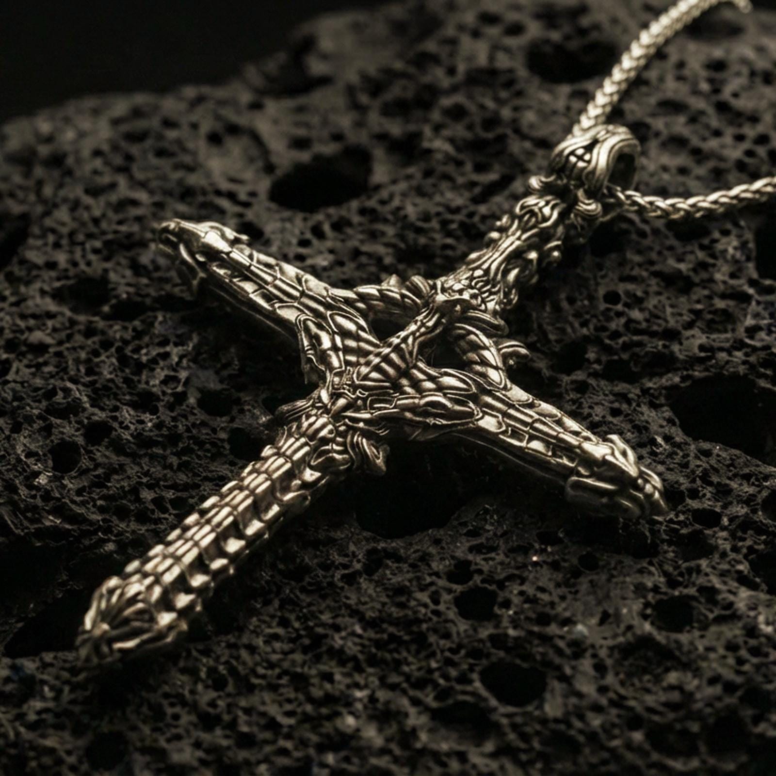 Bronze biomechanical gothic cross pendant with intricate skeletal and machine-like detailing displayed on dark volcanic rock in a close-up luxury jewelry composition