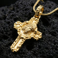 Load image into Gallery viewer, Gold plated Jesus crucifix pendant on black volcanic rock showing crown of thorns and sacred portrait.
