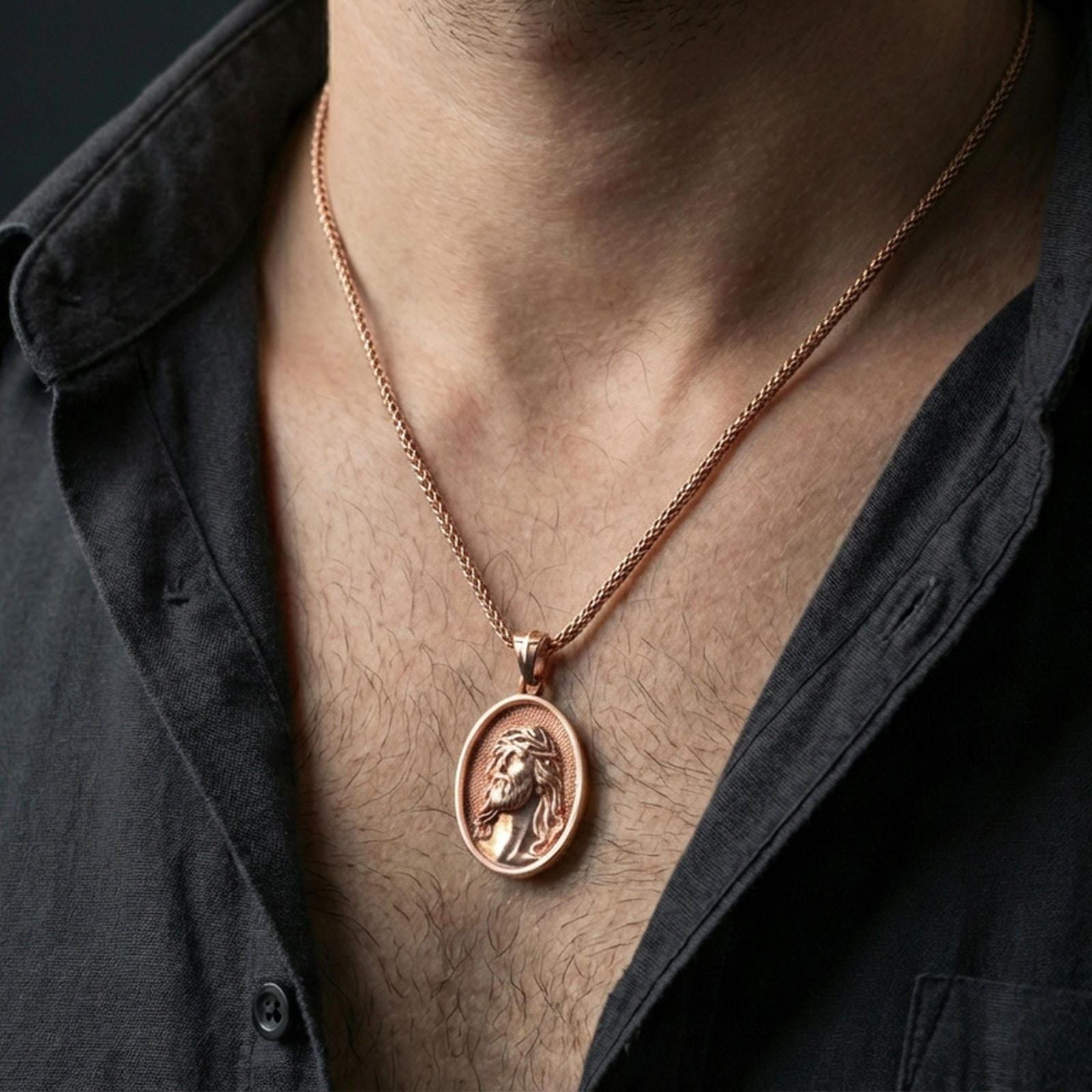 Rose gold plated religious Jesus medal with detailed sacred portrait worn on the neck in a refined lifestyle shot with a warm and elegant presentation