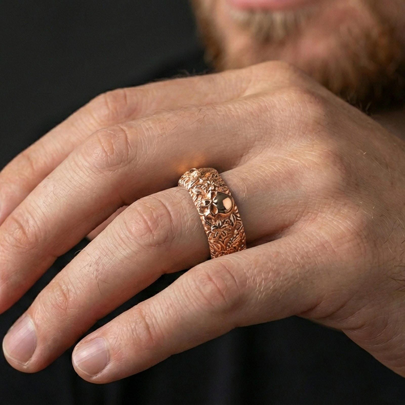 Rose gold plated skull and koi floral band ring worn on a finger, lifestyle wear shot with elegant rosy shine and crisp skull-and-koi floral detailing visible.
