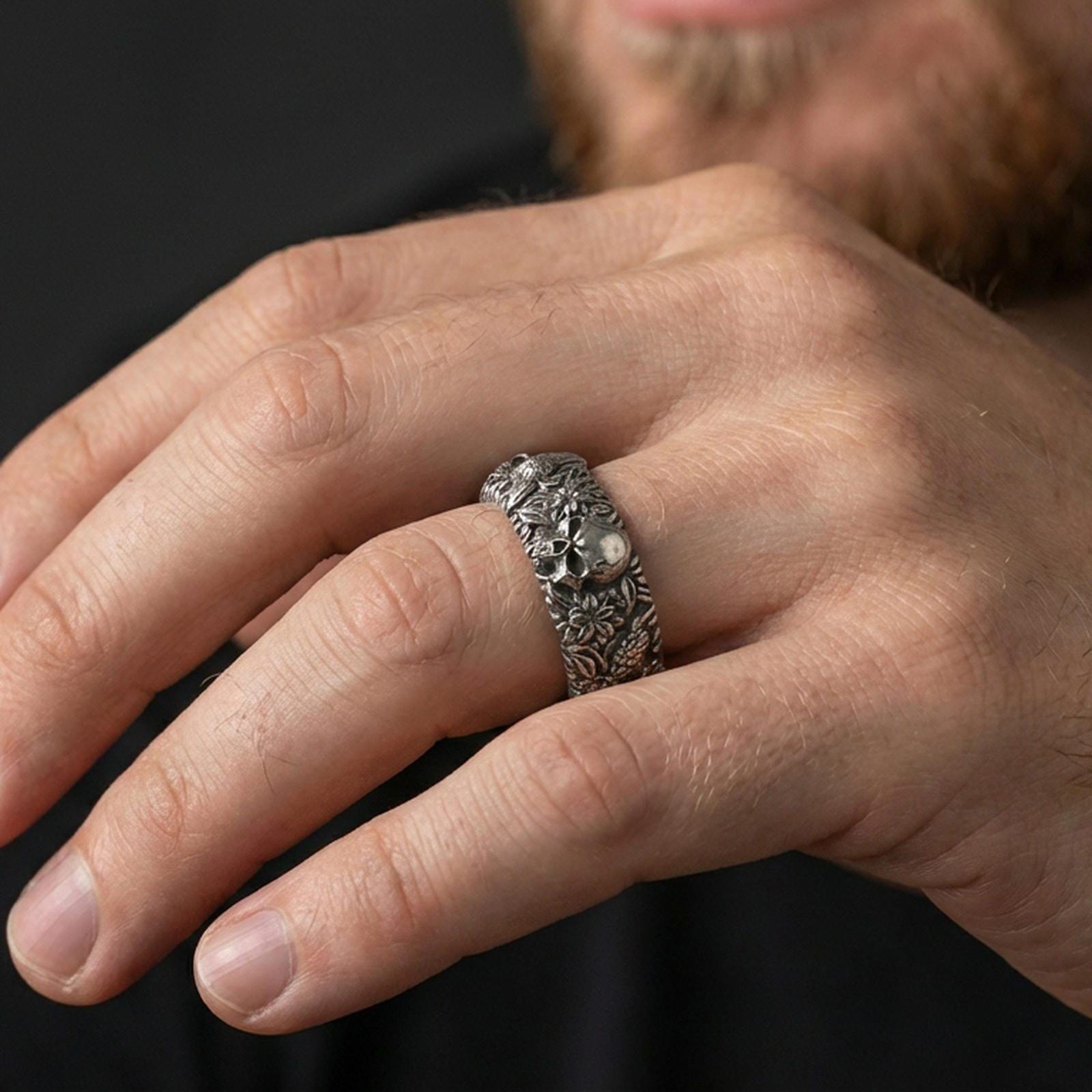 Oxidized skull and koi floral band ring worn on a finger, lifestyle framing showing realistic scale and bold vintage contrast in a natural hand pose.