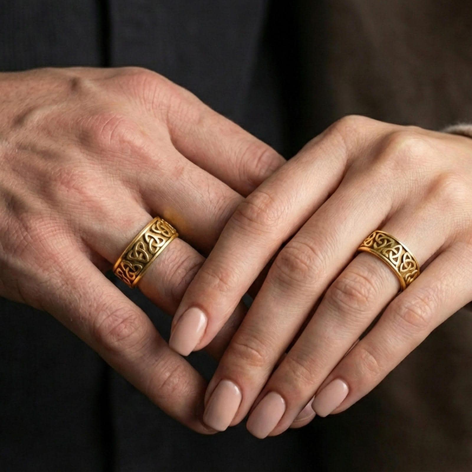 Gold plated Celtic triquetra band ring worn on a finger, lifestyle photo featuring warm tone finish and strong statement band presence.