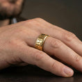 Load image into Gallery viewer, Gold plated Egyptian symbols band ring worn on a finger, lifestyle photo featuring warm tone finish and strong statement band presence.

