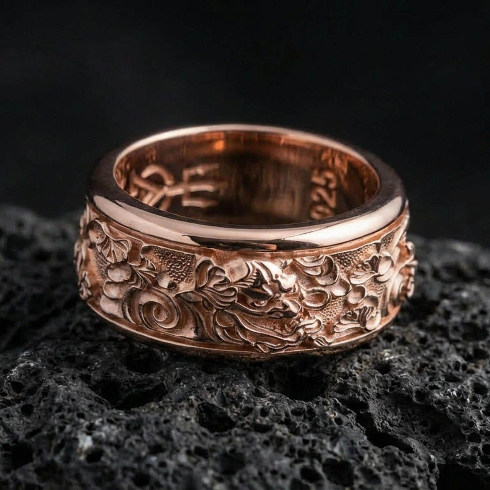 Rose gold plated oriental dragon band ring on textured volcanic rock, centered studio-style close-up showcasing soft rosy glow and intricate dragon-and-cloud detailing with a refined finish.