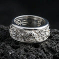 Load image into Gallery viewer, Polished silver oriental dragon band ring on textured volcanic rock, crisp macro product photo emphasizing clean edges, sharp dragon scales and facial detailing, and bright reflective highlights across the band.
