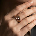 Load image into Gallery viewer, Rose gold plated face relief band ring worn on a finger, lifestyle wear shot with elegant rosy shine and crisp face detailing visible.
