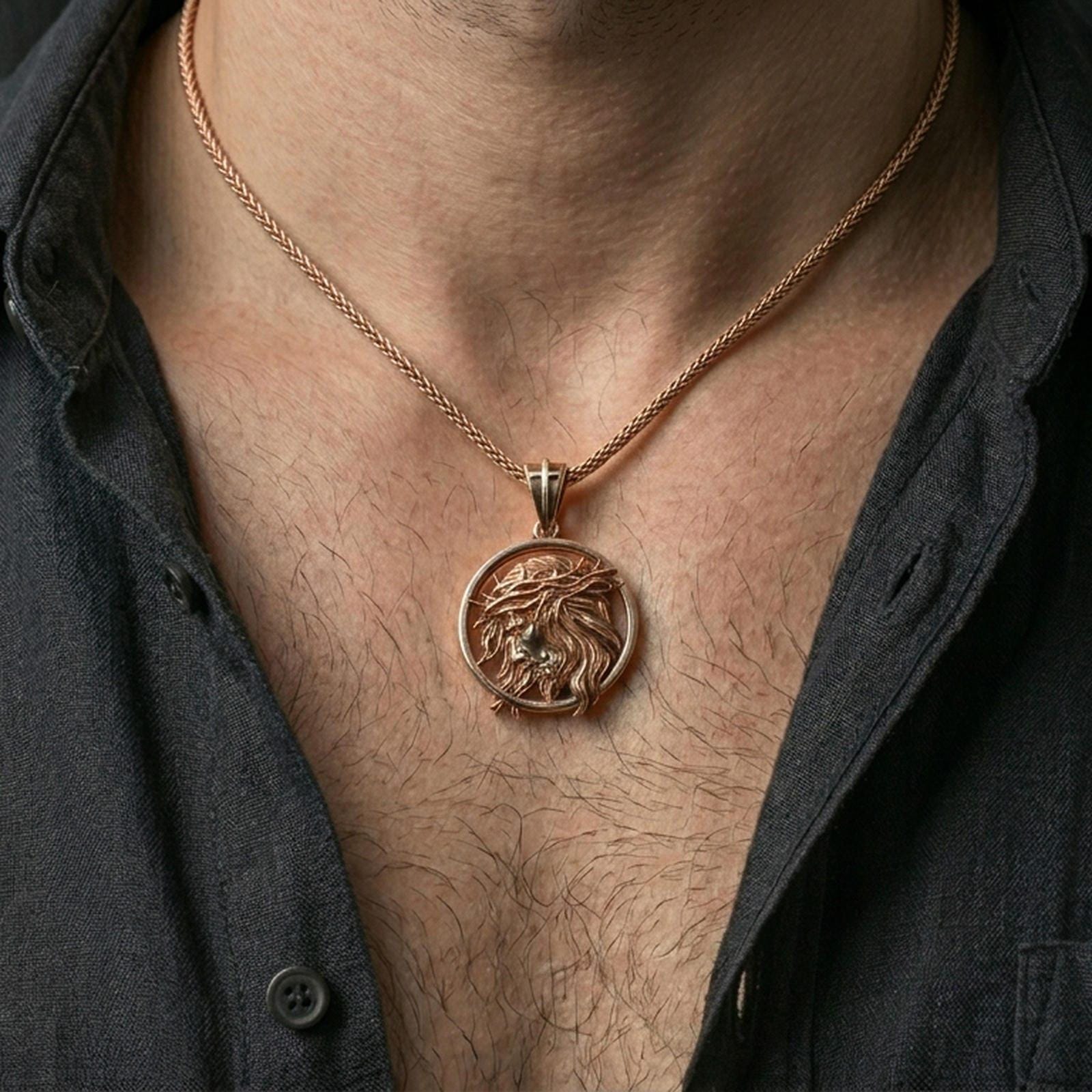 Rose gold plated religious Jesus pendant with circular portrait and crown of thorns worn on the neck in a refined lifestyle shot with a warm and elegant presentation