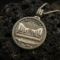 Load image into Gallery viewer, Bronze Last Supper pendant with Pray for Us inscription, detailed round medallion design, and two-sided devotional concept displayed on dark volcanic rock in a close-up luxury jewelry composition

