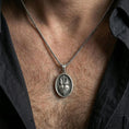 Load image into Gallery viewer, Oxidized Sacred Heart pendant worn on the neck in a lifestyle jewelry shot, styled against the chest for a bold and devotional look
