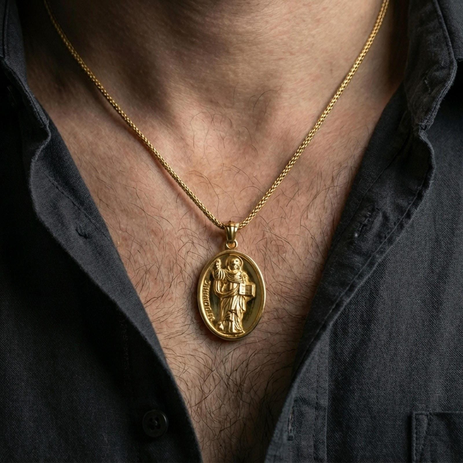 Gold plated Saint Dominic necklace with saint figure and book motif worn on the neck in a premium lifestyle composition with classic Christian jewelry styling