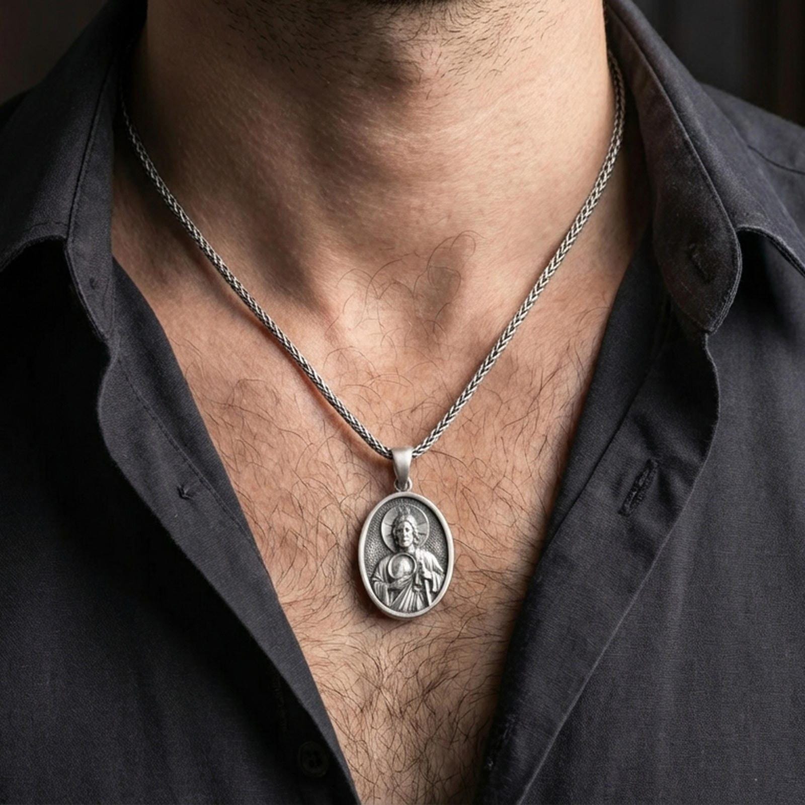 Oxidized Saint Jude pendant with haloed saint figure worn on the neck in a lifestyle jewelry shot, styled against the chest for a devotional and timeless look