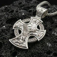 Load image into Gallery viewer, Polished silver Archangel Michael pendant with ornate cross frame, angel warrior relief, and intricate religious scene placed on textured volcanic rock in a premium studio product shot
