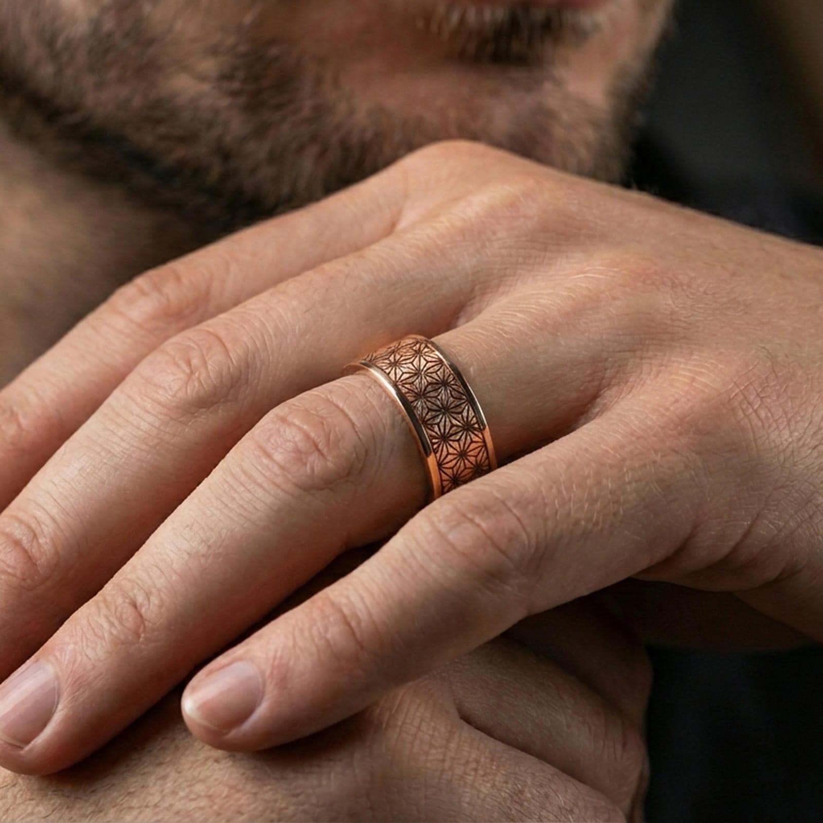 Rose gold plated geometric floral band ring worn on a finger, lifestyle wear photo with elegant rose tone and crisp floral-geometry pattern definition.