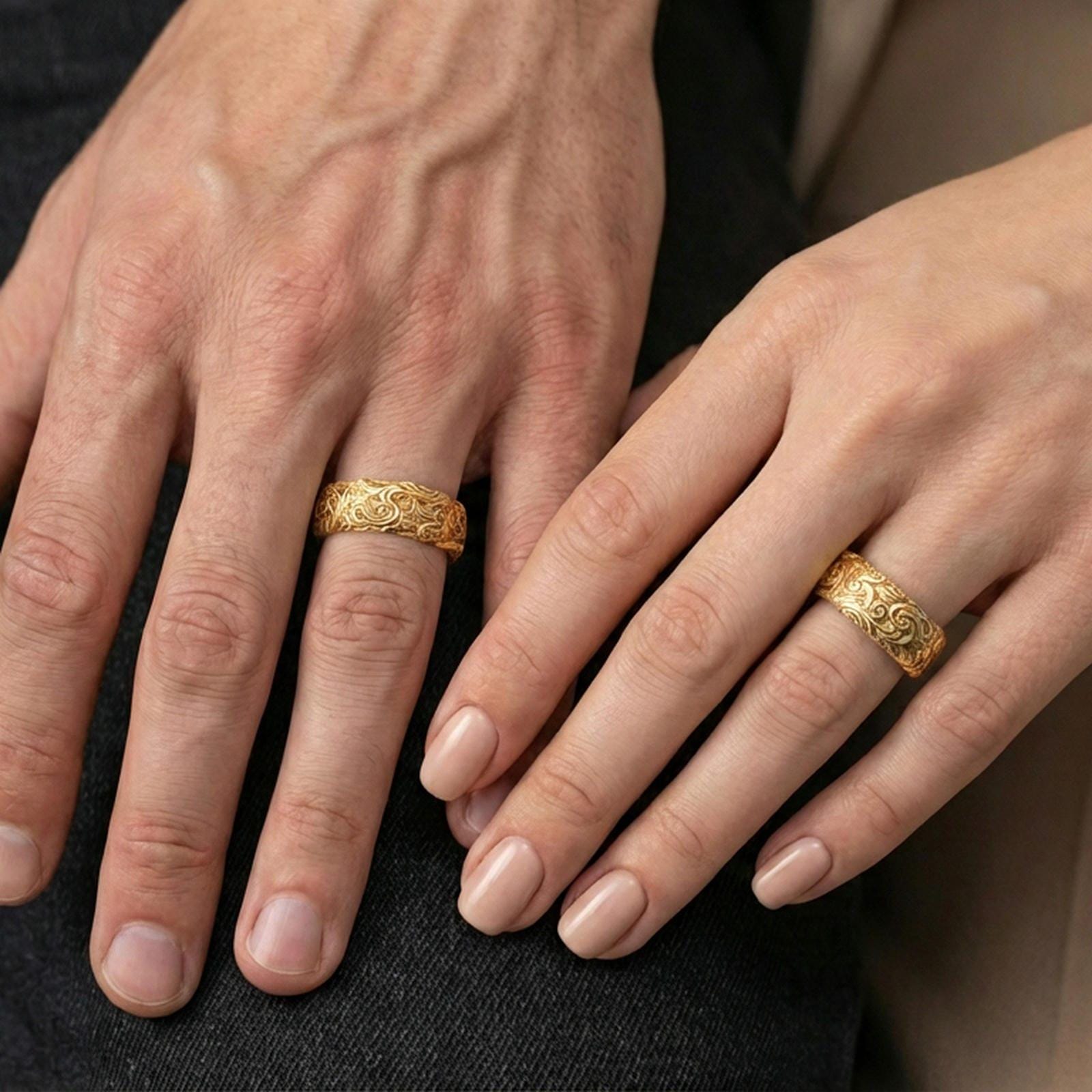 Gold plated scrollwork band ring worn on a finger, lifestyle shot emphasizing luxurious gold tone and continuous baroque-style engraving.