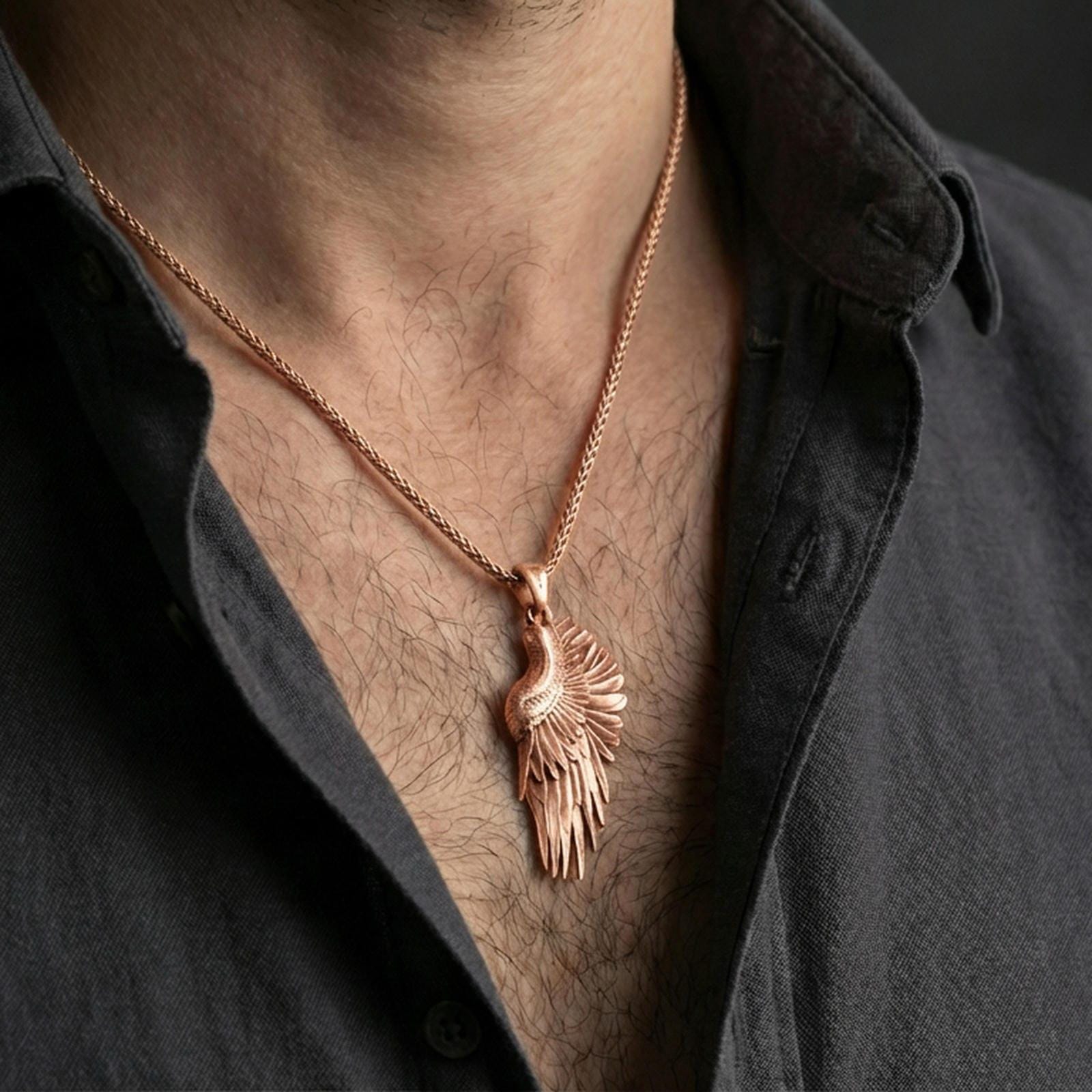 Rose gold plated wing pendant with detailed feather relief worn on the neck in a refined lifestyle shot with a warm and elegant presentation