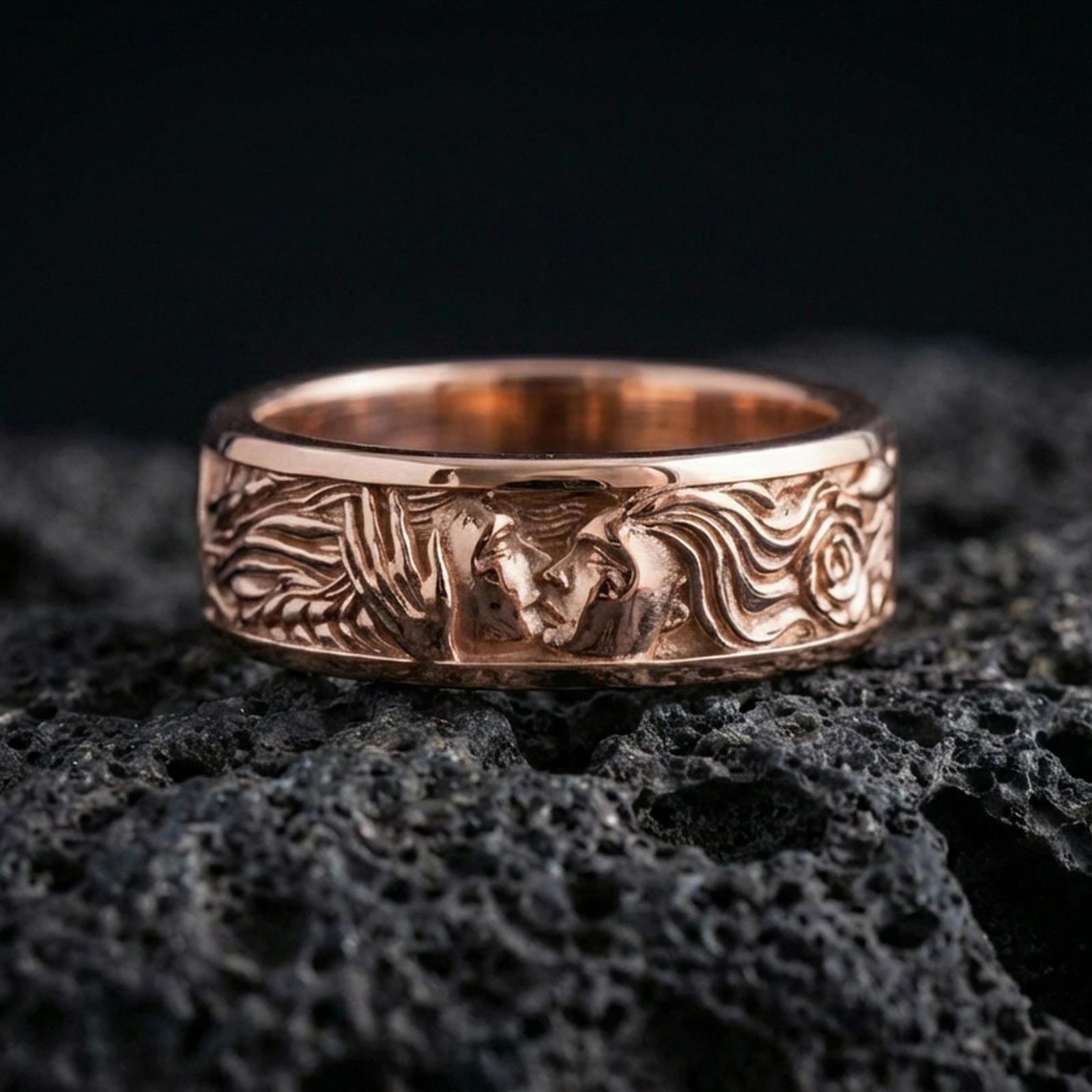 Rose gold plated lovers face ring on volcanic stone, refined close-up featuring soft rose highlights on the couple relief and ornamental flowing hair lines.