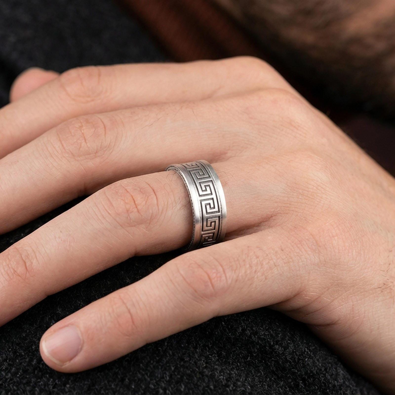 Oxidized sterling silver Greek key spinner ring worn on a finger, lifestyle wear image focusing on the rotating band detail and bold antique contrast.