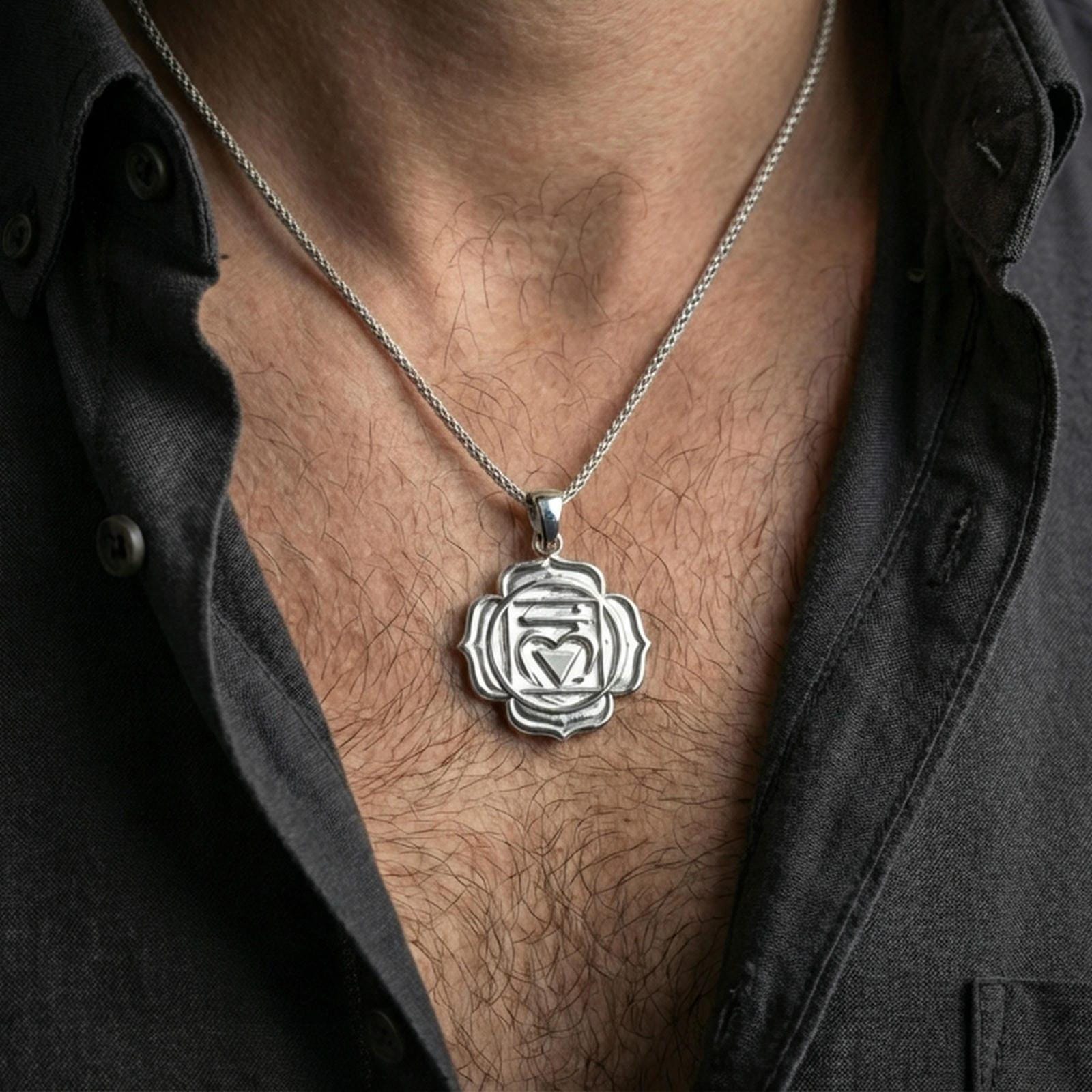 Polished silver chakra medallion with raised heart chakra emblem and lotus-inspired frame worn on the neck in a close lifestyle frame, highlighting the balanced geometry and symbolic design