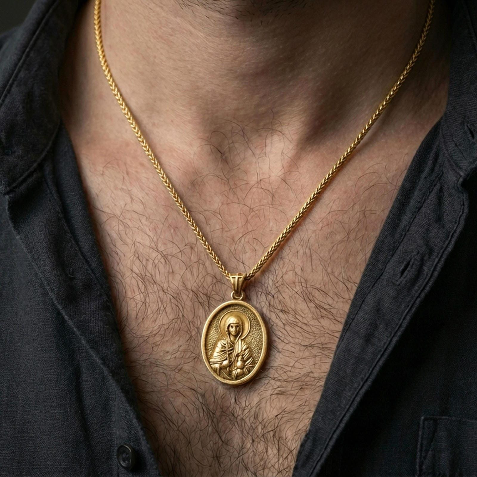 Gold plated Saint Anastasia necklace with haloed saint portrait and cross motif worn on the neck in a premium lifestyle composition with classic Christian jewelry styling
