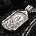 Load image into Gallery viewer, Polished silver Saint Anastasia medallion with detailed saint relief, halo motif, and engraved geometric background placed on textured volcanic rock in a premium studio product shot
