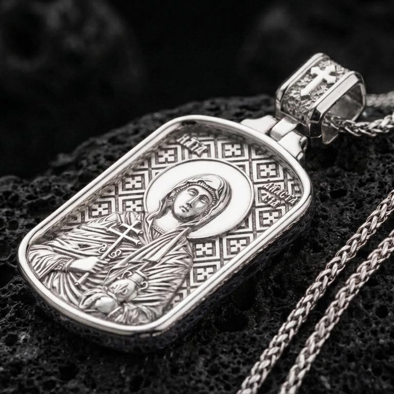 Polished silver Saint Anastasia medallion with detailed saint relief, halo motif, and engraved geometric background placed on textured volcanic rock in a premium studio product shot