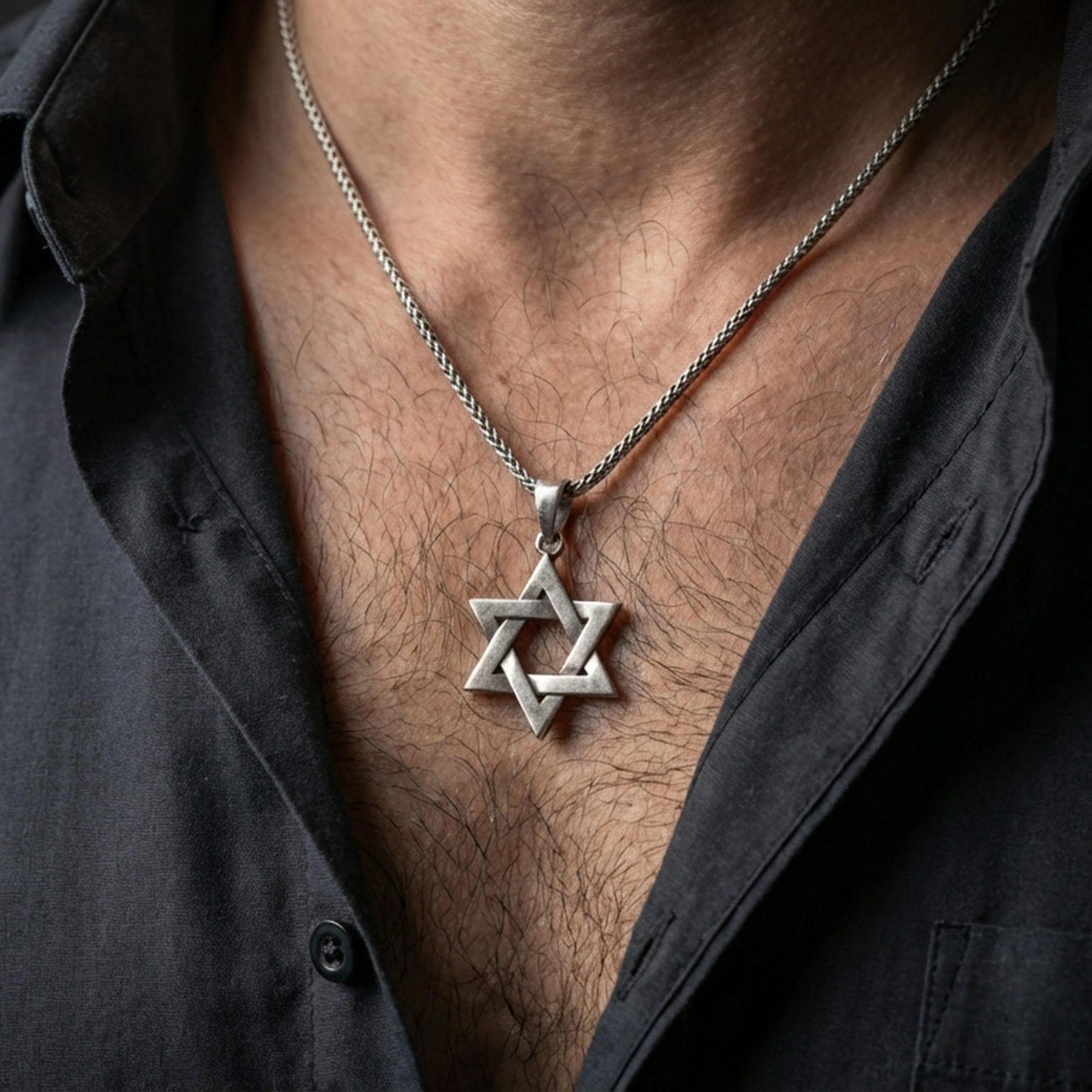 Oxidized Star of David pendant worn on the neck in a lifestyle jewelry shot, styled against the chest for a bold and meaningful look