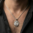 Load image into Gallery viewer, Polished silver Saint Joseph medallion with Child Jesus and halo detail worn on the neck in a close lifestyle frame, highlighting the sacred portrait and refined oval design
