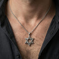 Load image into Gallery viewer, Oxidized Star of David pendant with engraved hexagram design worn on the neck in a lifestyle jewelry shot, styled against the chest for a bold and meaningful look
