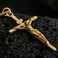Load image into Gallery viewer, Gold plated crucifix pendant on volcanic stone, premium macro close-up showcasing warm gold tone across the cross and figure, with defined sculpted depth.
