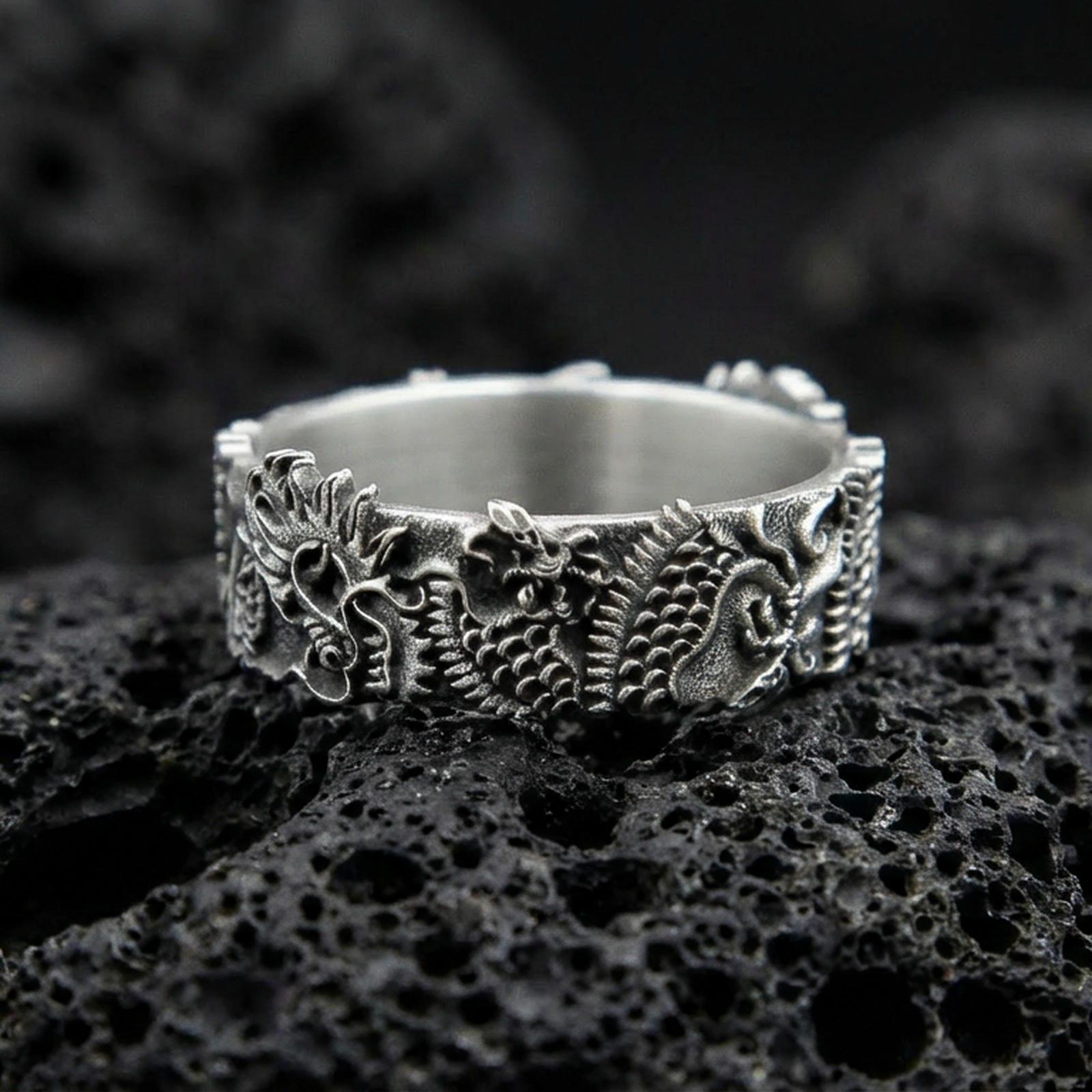Oxidized sterling silver Japanese dragon band ring on volcanic stone, macro close-up emphasizing deep carving, scales, and high-contrast antique detailing.