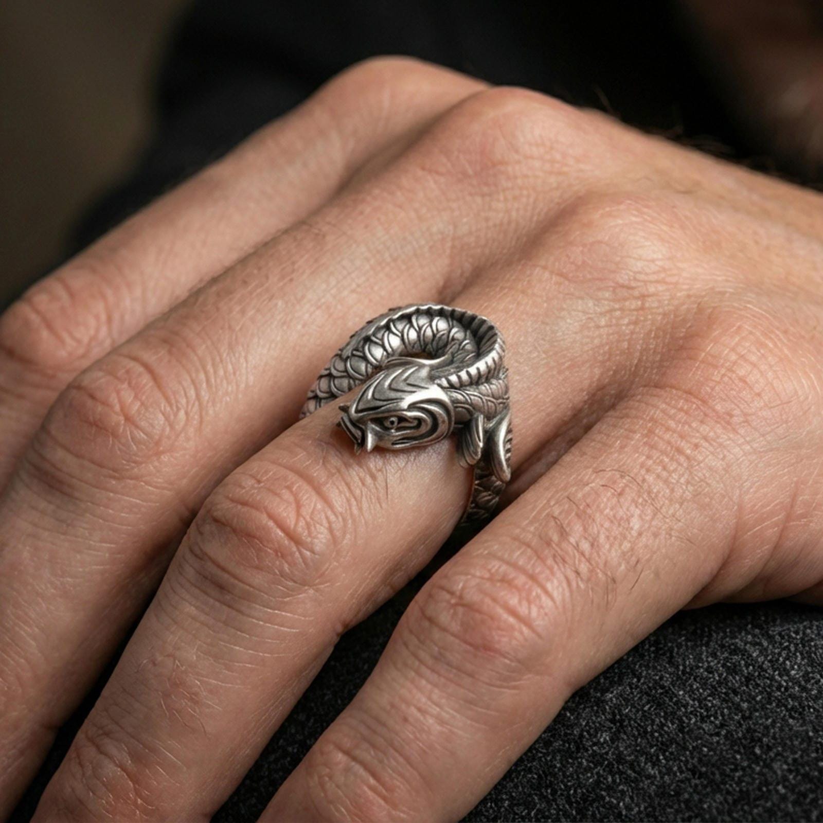 Oxidized sterling silver koi fish wrap ring worn on the finger, lifestyle photo focusing on bold contrast, sculpted koi head, and statement coil silhouette.