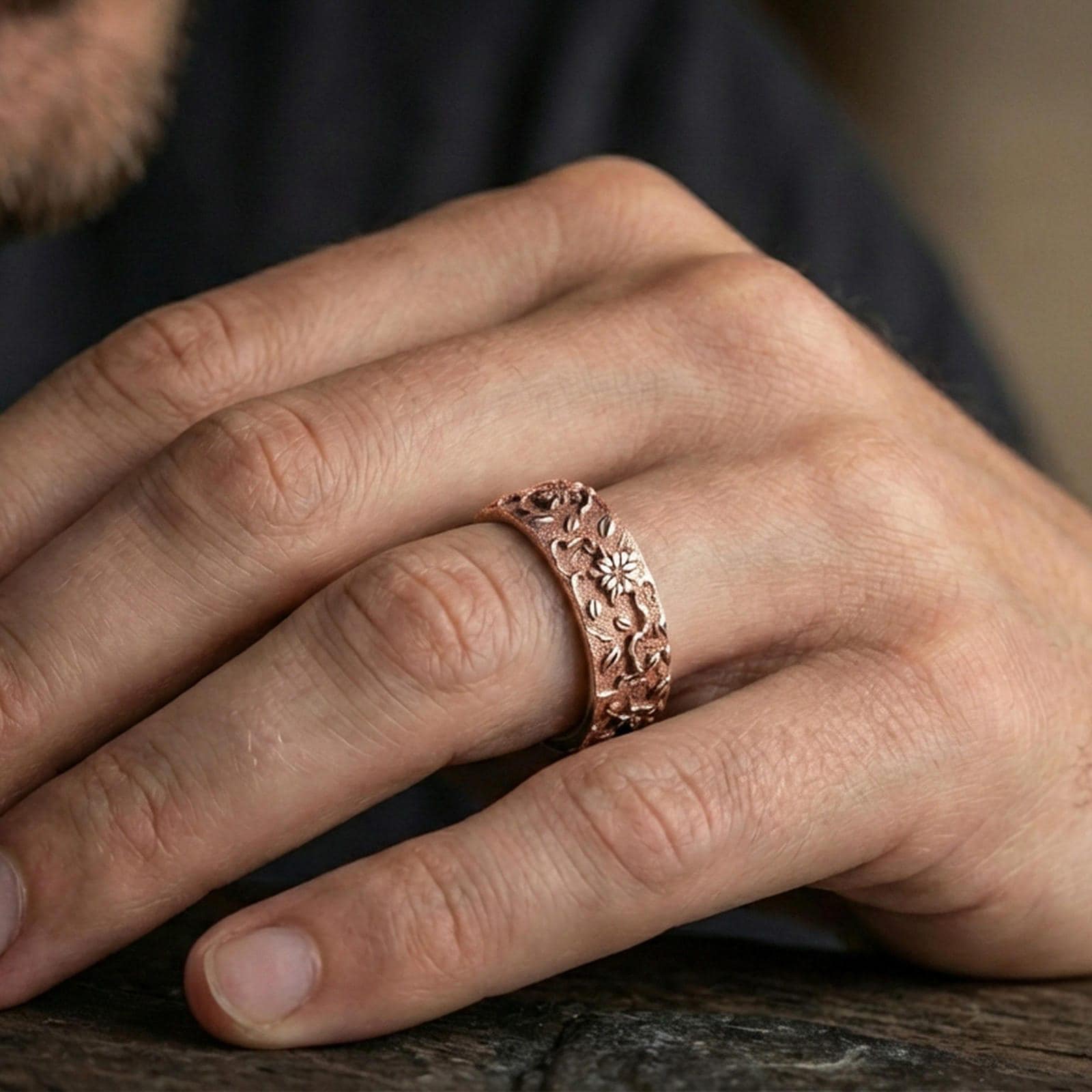 Rose gold plated floral engraved band ring worn on the finger, lifestyle image showcasing warm rose tone, intricate flower engraving, and elegant minimal pairing.