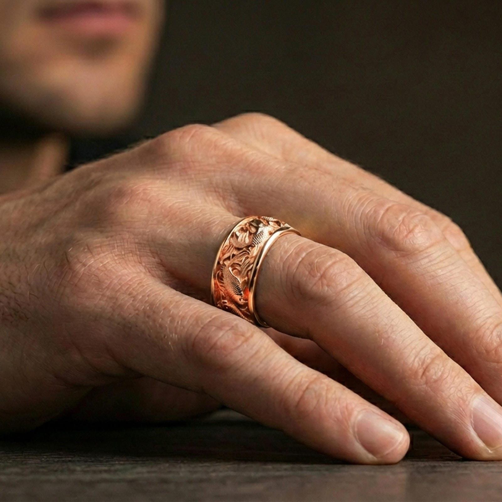 Rose gold plated koi fish band ring worn on the finger, lifestyle image showcasing refined rose tone, intricate koi texture, and modern stacking appeal.